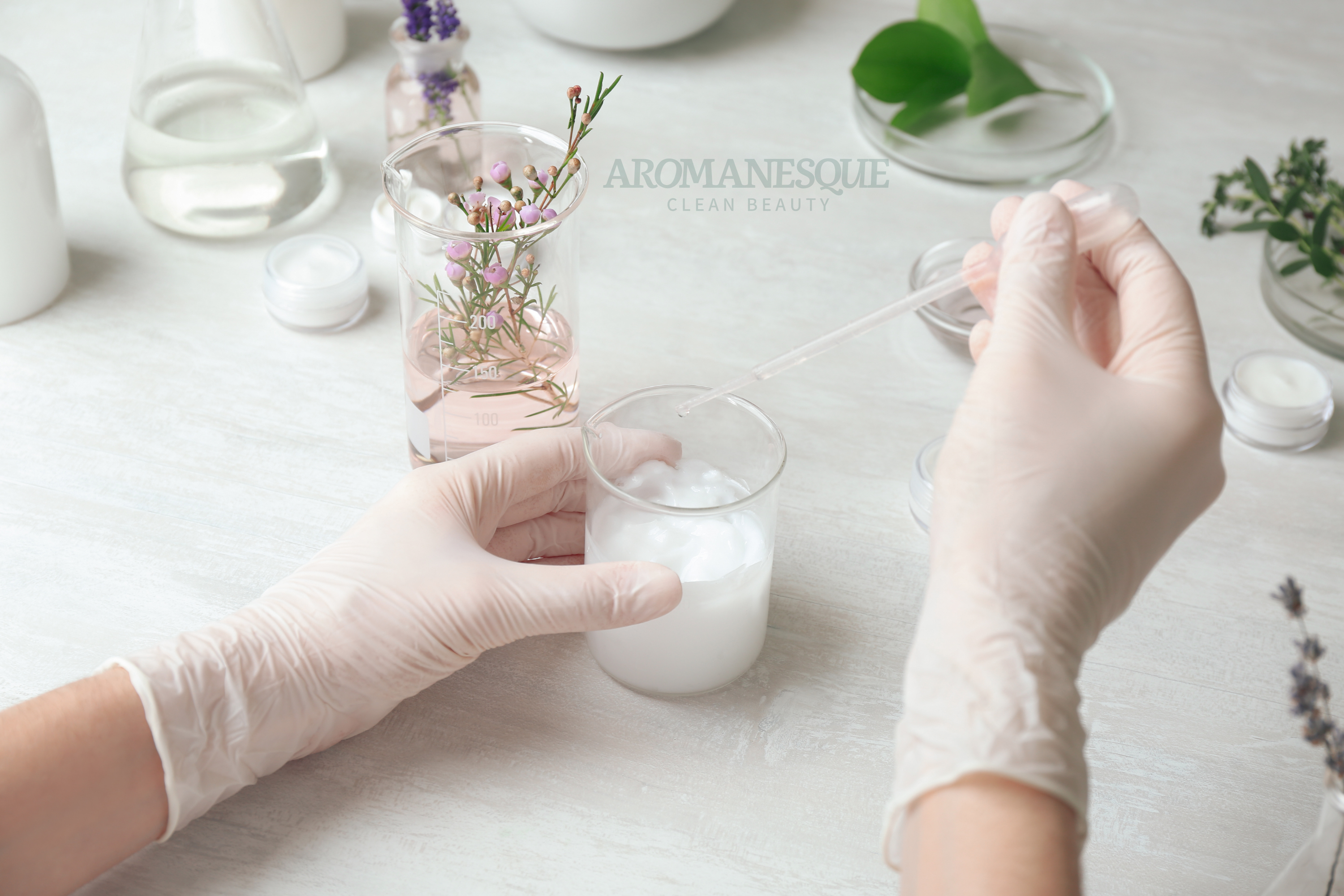 A person wearing gloves is searching and developing formulas for Aromanesque brand.